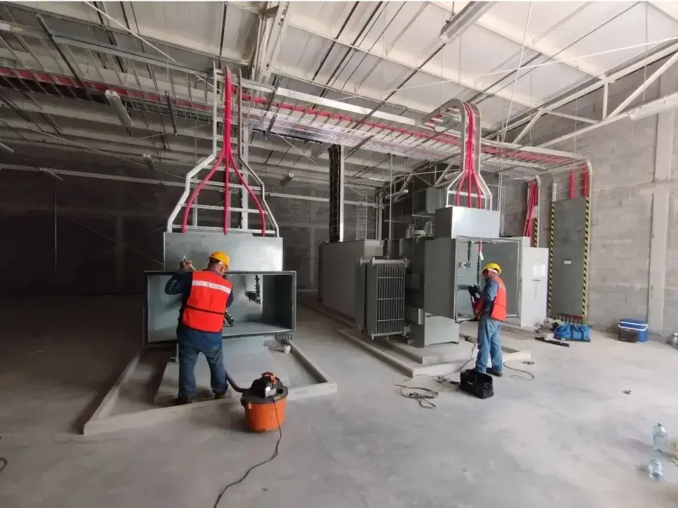 Fotografía de personal de MTY Breaker dentro de una empresa realizando tareas de mantenimiento a instalaciones eléctricas.