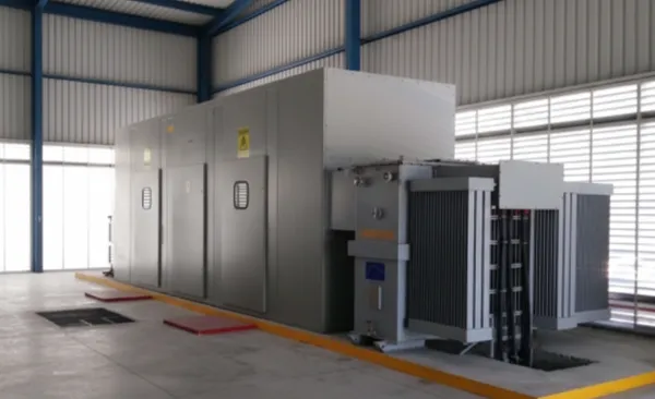 Una de las subestaciones compactas instaladas dentro de una nave industrial, con un diseño cerrado y robusto, paredes metálicas y puertas de acceso laterales.