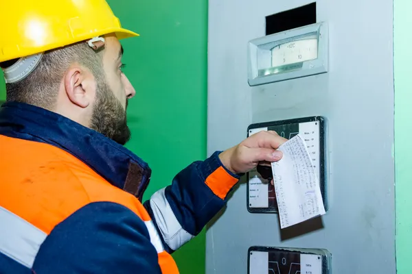 Vista de la parte posterior de un técnico haciendo un dictamen de verificación de instalaciones eléctricas
